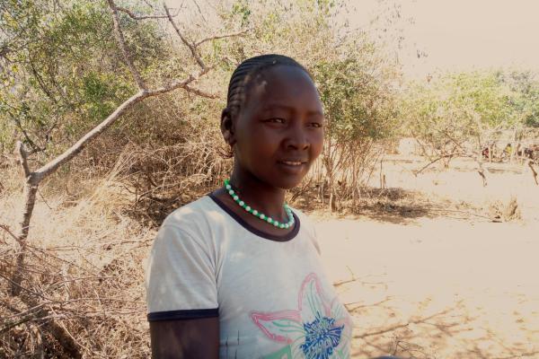 A woman standing in front of bushes